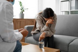 Seorang ibu yang tampak stres sebelum mengikuti persiapan hipnoterapi online untuk manajemen emosi.
