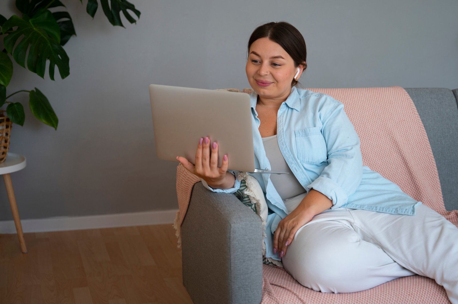 Ibu hamil melakukan persiapan hipnoterapi online melalui laptop di ruang santai.