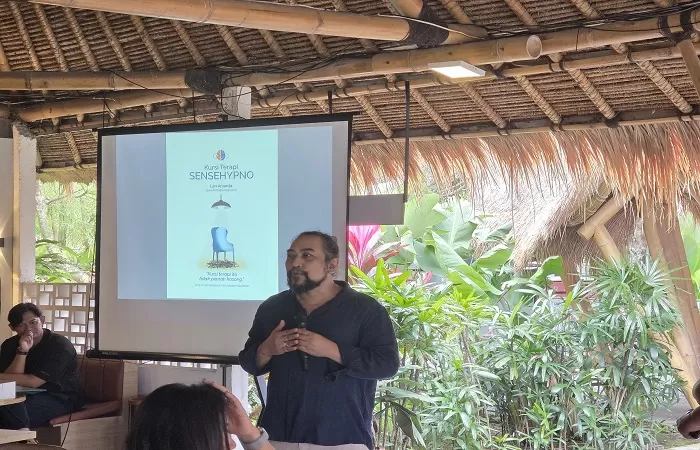 Terapis hipnoterapi Bali profesional sedang menjelaskan proses terapi trauma kepada klien